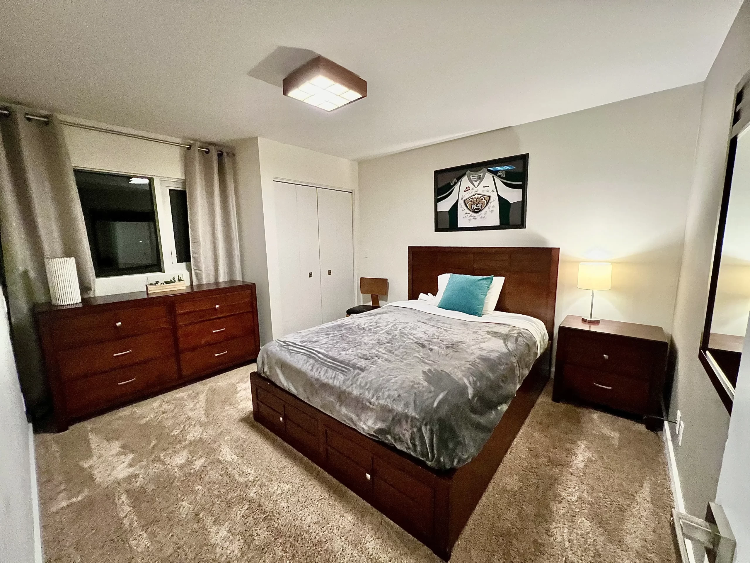 Serene lower-level queen bedroom at Naakef Travel Nurse Stay – Lake Forest Park nestled among gardens, featuring quiet seclusion and peaceful natural surroundings.