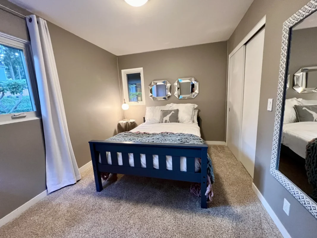 Comfortable queen bedroom at Naakef Travel Nurse Stay – Lake Forest Park with garden views, modern furnishings, and access to shared kitchen and laundry facilities.