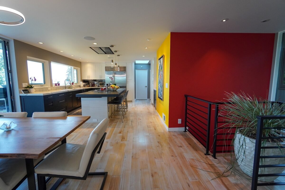 Dining area featuring a unique modern chandelier and large folding doors opening to the deck at Naakef Travel Nurse Stay – Lake Forest Park.