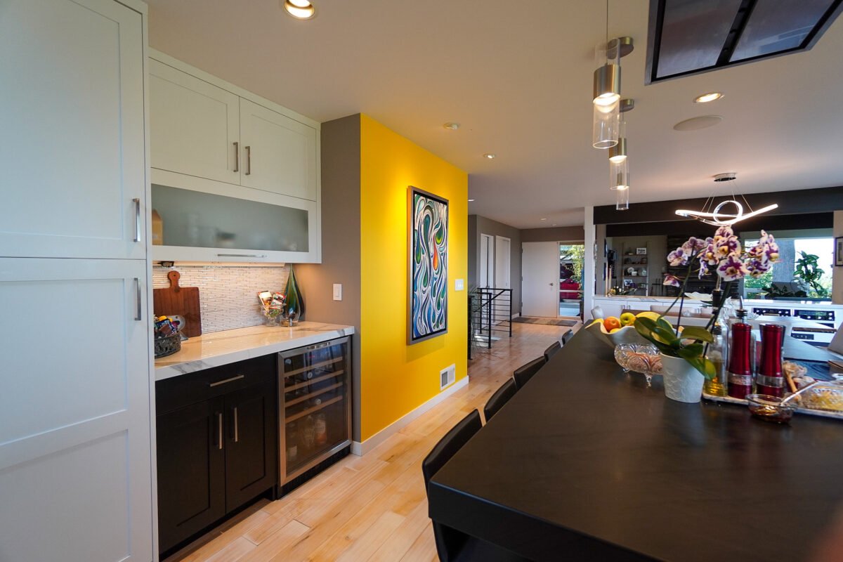Bright open-concept kitchen and dining space with hardwood floors and vibrant accent walls at Naakef Travel Nurse Stay – Lake Forest Park.
