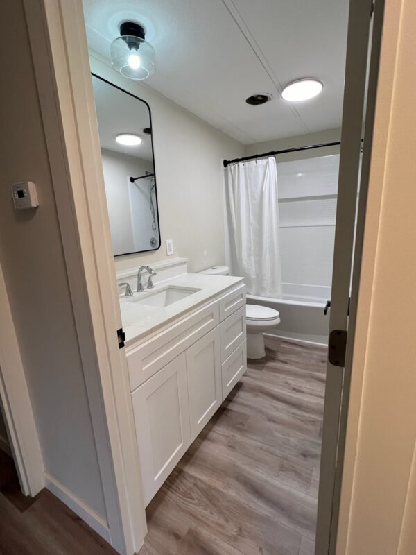 Bright and stylish bathroom featuring a sink, white quartz countertops, and a walk-in shower at Naakef Private Home Rentals – Seatac.
