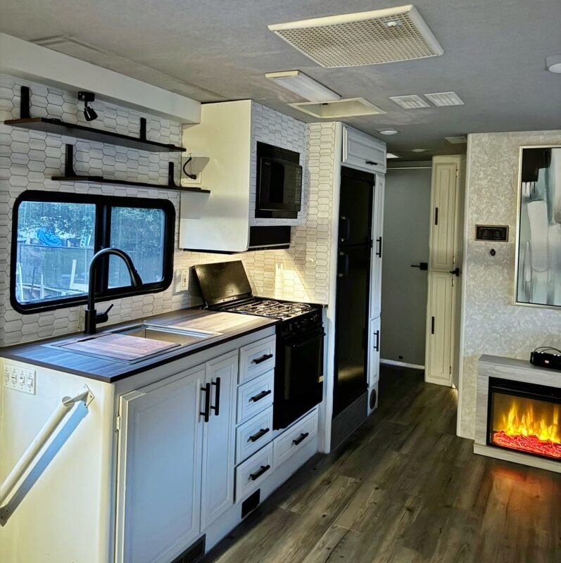 Modern kitchen design highlighting white shaker cabinets, stainless steel appliances, and a beautiful blue tile backsplash at Naakef Private Home Rentals – Seatac.