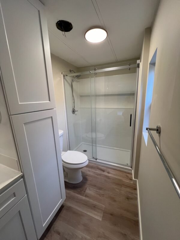 Clean and modern bathroom showcasing a spacious walk-in shower with sliding glass doors at Naakef Private Home Rentals – Seatac.