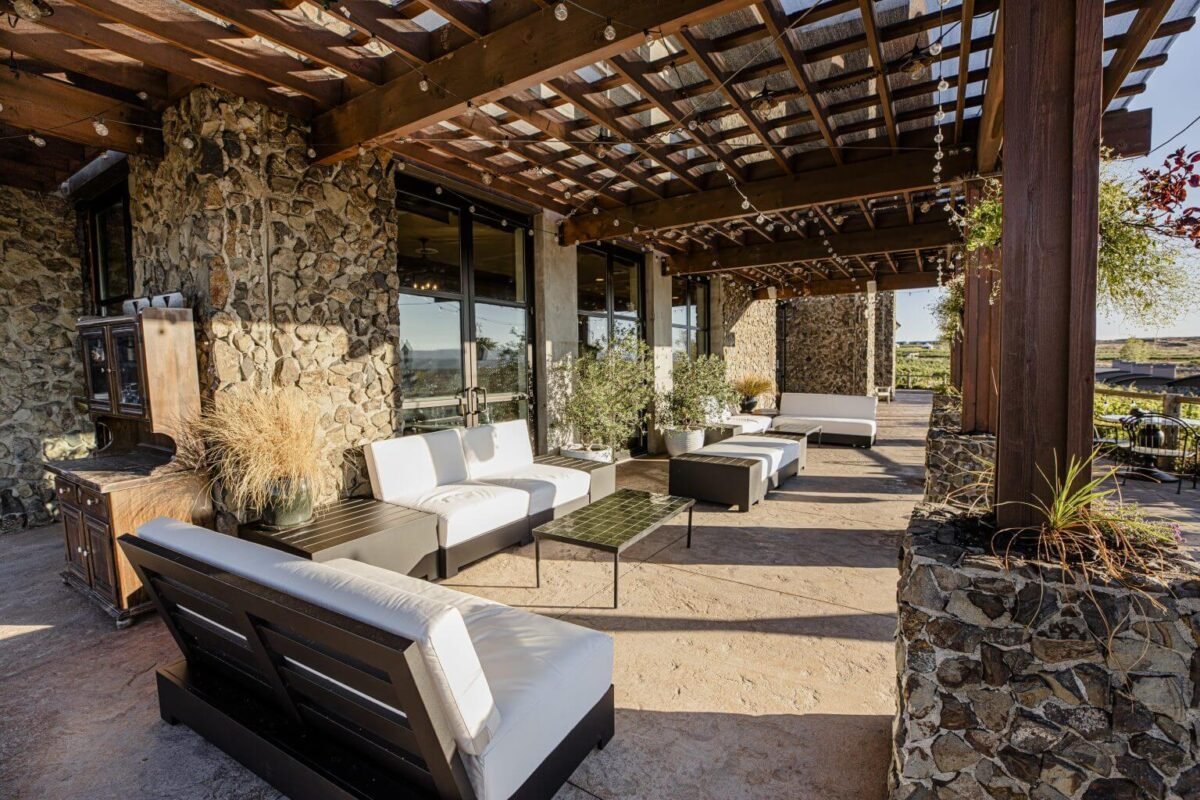 Spacious outdoor patio with comfortable lounge seating and pergola shading, offering relaxing vineyard views at Sagecliffe Residences by Naakef.