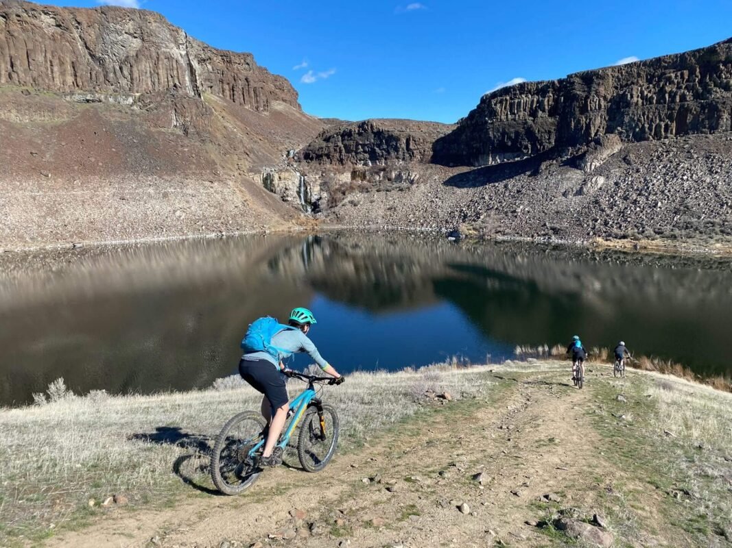 Cyclist riding along a scenic trail with stunning river canyon views surrounded by natural rock formations at Sagecliffe Residences by Naakef.