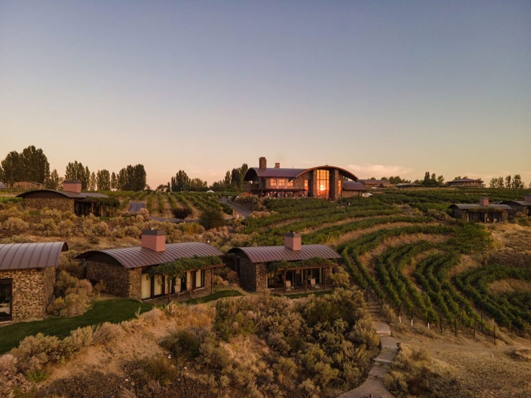 Breathtaking sunset view of the entire Sagecliffe Residences by Naakef complex featuring cabins, vineyards, and the dramatic river gorge beyond.