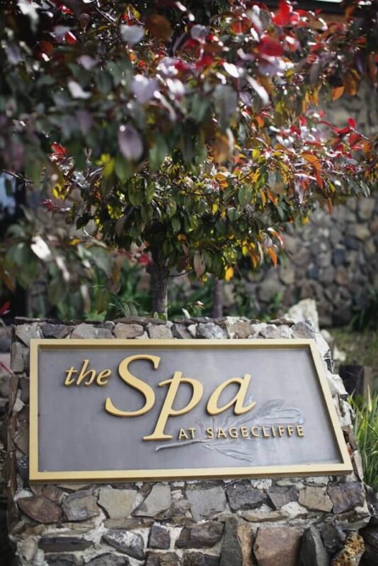 Elegant stone entrance sign reading "the Spa at Sagecliffe" adorned with autumn foliage at Sagecliffe Residences by Naakef.